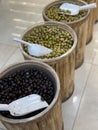 Barrels filled with assorted olives in a market setting with scoops on display Royalty Free Stock Photo