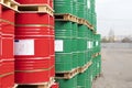 Barrels of 200 liters of metal are in the pallet on the street. Red and green barrels for petroleum, chemicals, gasoline.