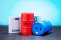 Barrels of oil, euro banknotes on blue background.