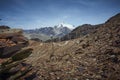 Barren land shows a small road and the Chacaltaya mountain appears in the background