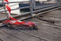 Barricade tape remains and rusty chains on wooden boards of bridge