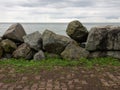 Barrier of large stones on the seashore. Wave protection. Irregular stones. Sea shore