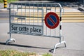 Barrier for no parking in front of pedestrian crossing. Sign in French: on this square in Lausanne, Switzerland.