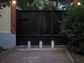 Barrier retractable bollards in front of the iron gates and with burning lanterns on the walls