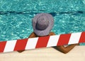 Barrier tape - quarantine, isolation concept, entry ban. Do not cross. Young sexy woman in hat relaxing at the pool