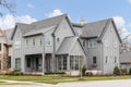 A large grey modern farmhouse with large windows.