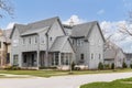 A large grey modern farmhouse with large windows.