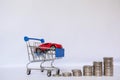 A barrow small shopping cart with coins on a white background for economizing  buying cars Concept of economizing and buying cars Royalty Free Stock Photo