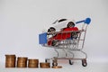 A barrow small shopping cart with coins on a white background for economizing  buying cars Concept of economizing and buying cars Royalty Free Stock Photo