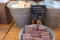 Bars of colourful home made soap in large metal pails for sale at a Farmers Market Royalty Free Stock Photo