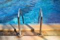Bars ladder in the blue swimming pool Royalty Free Stock Photo