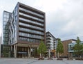 Bars restaurants and modern apartment buildings in the leeds dock area around a public square with trees and benches