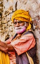 Barsana, India - February 23, 2018 - Old man with grey beard and yellow turbin rests in Holi festival Royalty Free Stock Photo
