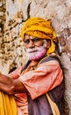 Barsana, India / February 23, 2018 - Old man with grey beard and yellow turbin rests in Holi festival Royalty Free Stock Photo