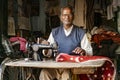 Tailor woks on manual sewing machine, creating tablecloth