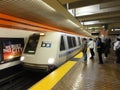 BART Train speeds into station platform with people waiting and Royalty Free Stock Photo