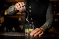 Bartender adding cane sugar into the cocktail glass with lime. P Royalty Free Stock Photo
