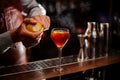 Bartender is adding lemon zest to the cocktail at bar counter. Selective focus Royalty Free Stock Photo