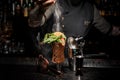 Bartender adding powder to a fresh summer cocktail with fruits Royalty Free Stock Photo