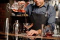 Bartender adding red alcoholic drink into the cocktail glass Royalty Free Stock Photo