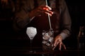 Bartender cooling out Cocktail glass mixing ice with a spoon