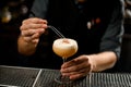 Bartender decorated the yellow creamy color alcoholic cocktail drink with a dried red pepper