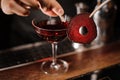 Bartender decorating a red cocktail drink with a slice of a beet Royalty Free Stock Photo