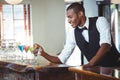 Bartender garnishing cocktail with olive