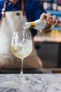 Bartender gently pour alcohol and soda in a wine glass with ice for making cocktail