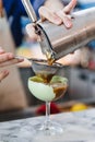 Bartender gently pour coffee mix with alcohol pass the filter in wine glass with green paste for making cocktail Royalty Free Stock Photo