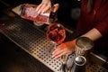 Bartender girl pouring a fresh campari cocktail