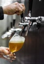 Bartender hand at beer tap pouring a draught beer in glass serving in a restaurant Royalty Free Stock Photo