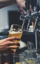 Bartender hand at beer tap pouring a draught beer in glass Royalty Free Stock Photo