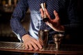 Bartender hand pouring a portion of pink alcohol drink into the shaker