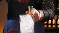 Bartender hands pouring cocktail ingredient in measuring cup or jigger