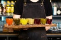 In bartender hands there is a colourful set of alcoholic cocktails in shot glasses shooters for an alcoholic party. Royalty Free Stock Photo