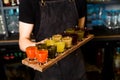 In bartender hands there is a colourful set of alcoholic cocktails in shot glasses shooters for an alcoholic party. Royalty Free Stock Photo