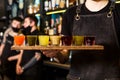 In bartender hands there is a colourful set of alcoholic cocktails in shot glasses shooters for an alcoholic party. Royalty Free Stock Photo