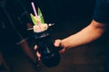 Bartender holding Cocktail near utensil strainer healthy drink on a bar counter . Professional view . Trendy stylish alcoholic