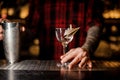 Bartender holding an empty cocktail glass ecorated with a paper