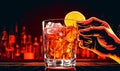 Bartender holding glass filled with alcoholic cocktail.