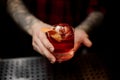 Bartender holding a glass of strong fresh whiskey cocktail Royalty Free Stock Photo