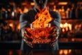 Bartender holding a glass of whiskey with ice in his hands, A glass of fiery cocktail on the bar counter against the background of Royalty Free Stock Photo