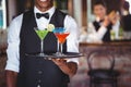 Bartender holding serving tray with cocktail glasses Royalty Free Stock Photo