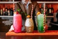 The bartender is holding three non Alcoholic  summer Cocktail. Alcoholic beverage based on table with ice cubes and oranges Royalty Free Stock Photo