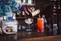 Bartender making cocktail pouring into a martini glass. Royalty Free Stock Photo