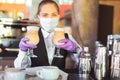 Bartender in medical mask and gloves makes latte coffee