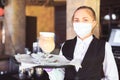 Bartender in medical mask and gloves makes latte coffee