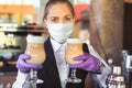 Bartender in medical mask and gloves makes latte coffee