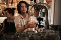 Bartender mixing drinks behind a bar counter at night Royalty Free Stock Photo